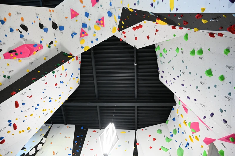 Kletterhalle mit Kletterrouten und Griffen Natursinne Schweiz Indoor Kletterhalle von oben mit bunten Griffen und Kletterrouten